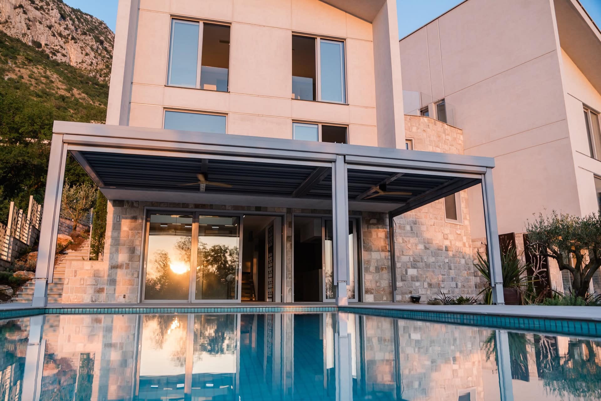 Modern villa with pool and terrace in Blizikuće, Montenegro: stone facade and panoramic windows.