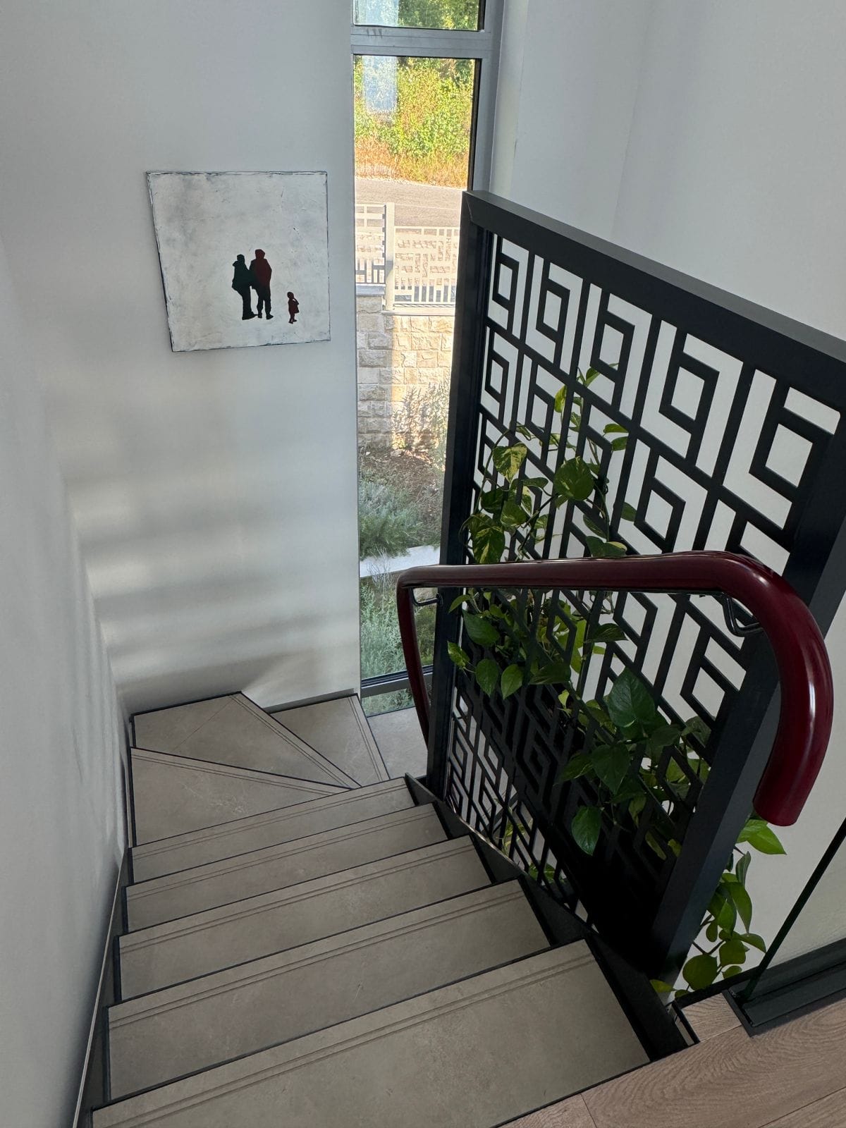 Modern staircase with decorative railing and a painting in a villa in Blizikuće, Montenegro.