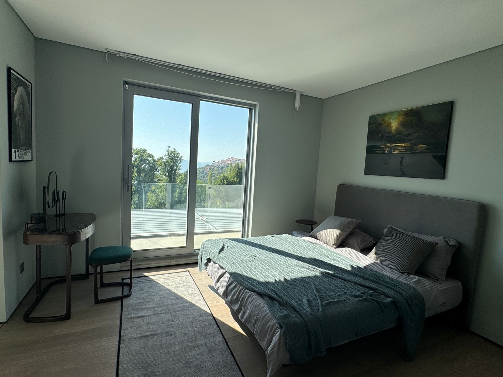 Modern bedroom in a villa in Blizikuće, Montenegro: double bed, vanity table, and panoramic mountain view.