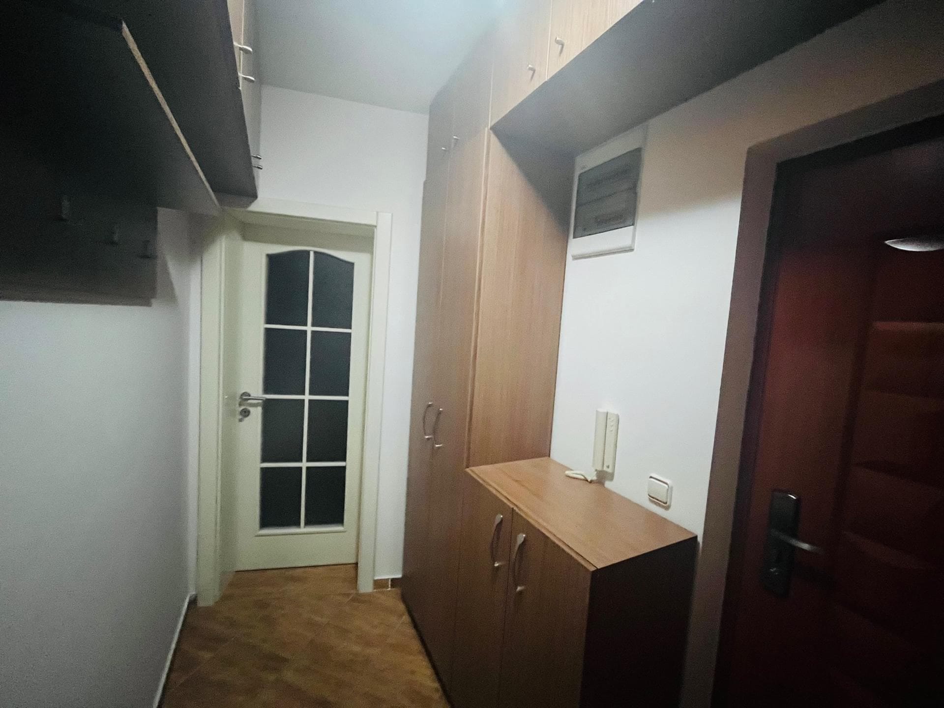 Hallway in an apartment in Sutomore, Montenegro: built-in wooden wardrobe, interior door with glass, and tiled floor.