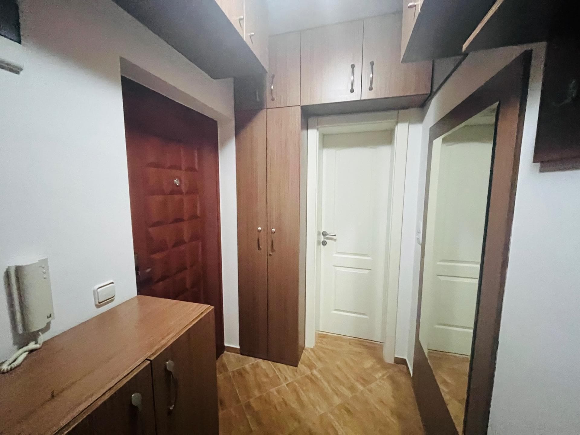 Hallway in an apartment in Sutomore, Montenegro: built-in wardrobe, mirror, and interior doors in a bright interior.