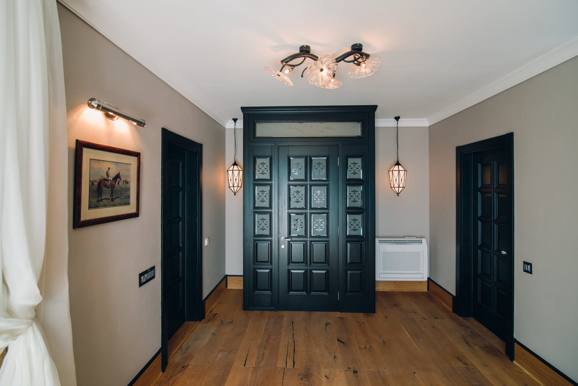 Villa hallway interior in Reževići, Montenegro: black interior doors, designer lighting, and wooden flooring.