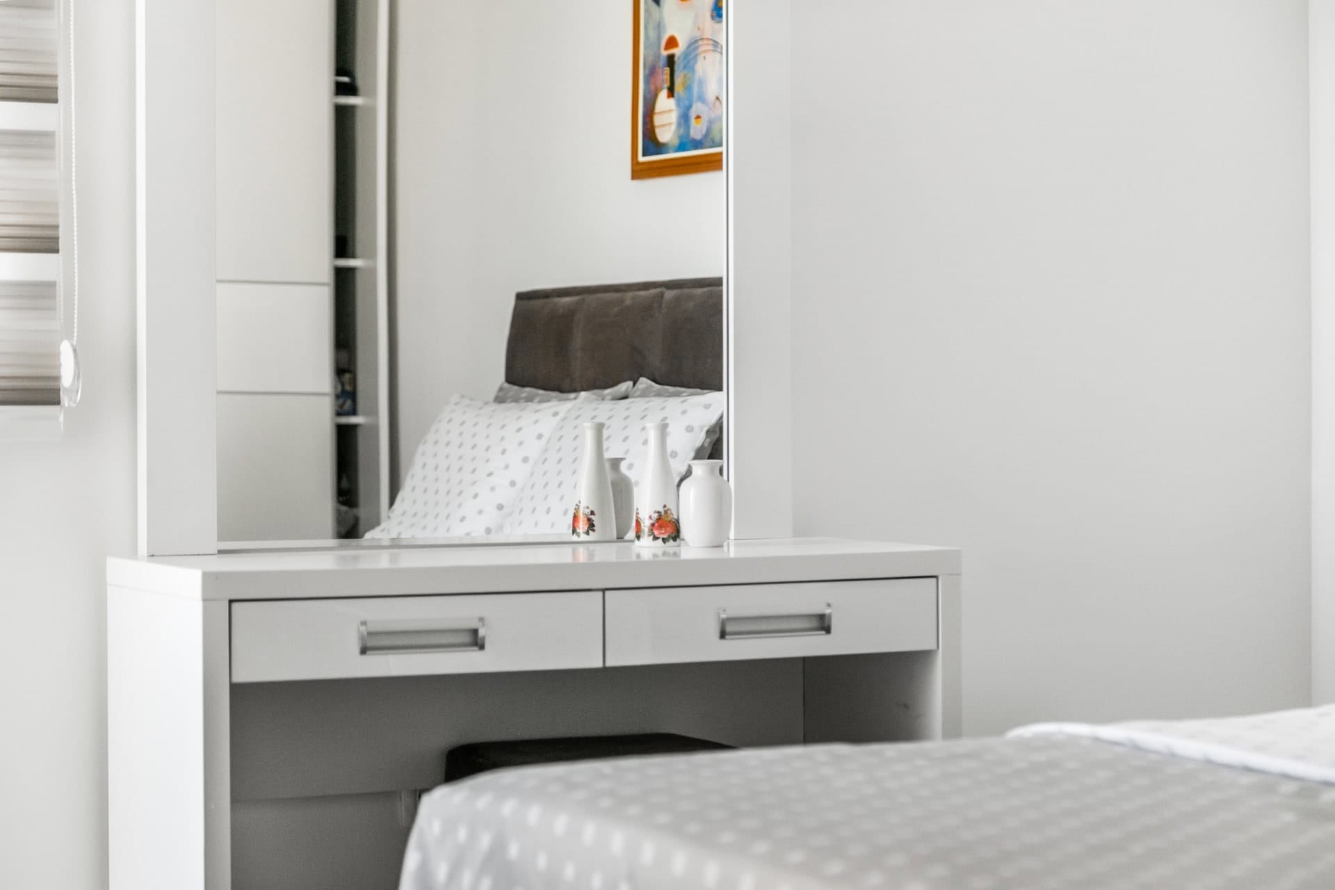 White vanity table with mirror in the bedroom interior of an apartment in Budva, Montenegro. Modern furniture and decor.