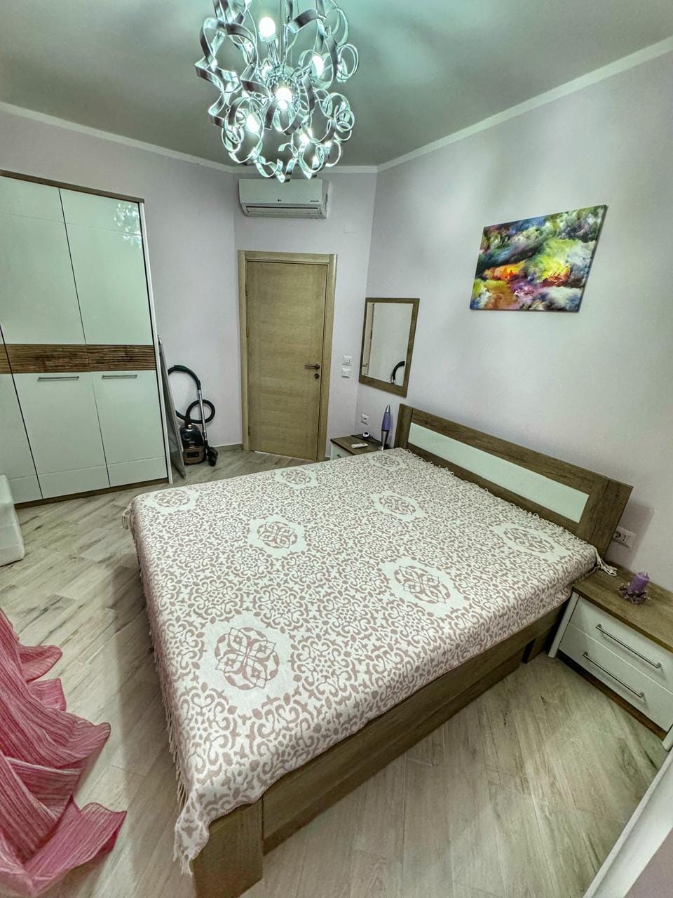 Cozy bedroom with a double bed and wardrobe in an apartment, Dobrota, Montenegro. Bright interior with air conditioning.