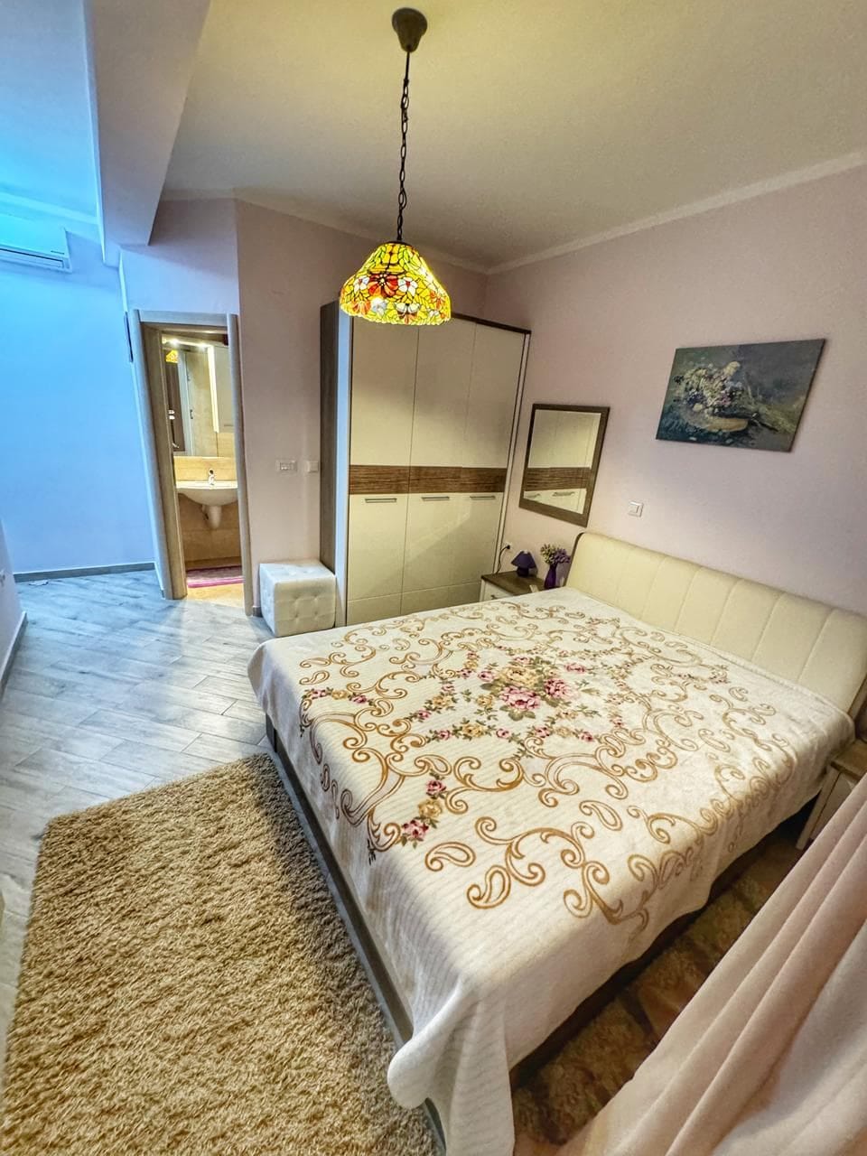 Cozy bedroom with a double bed and wardrobe in an apartment, Dobri Vody, Montenegro. View of the bathroom.