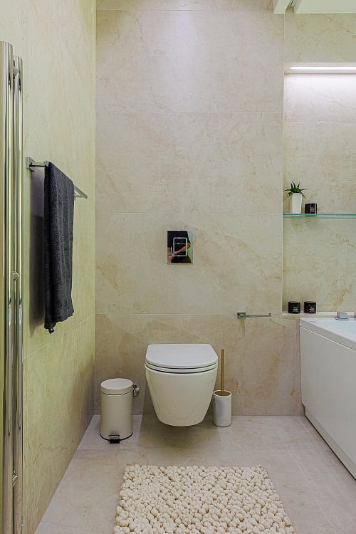 Modern bathroom in an apartment in Bečići, Montenegro: beige tiles, wall-hung toilet, and stylish decor.