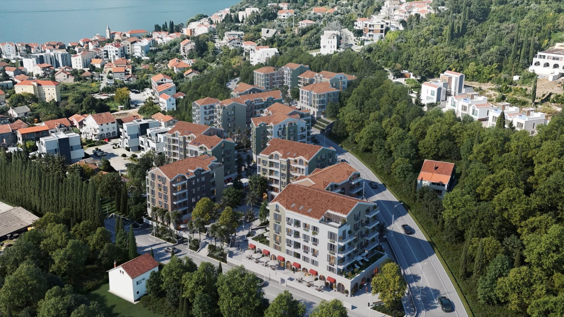 Aerial view of a residential complex in Tivat, Montenegro: modern houses with tiled roofs and green areas.