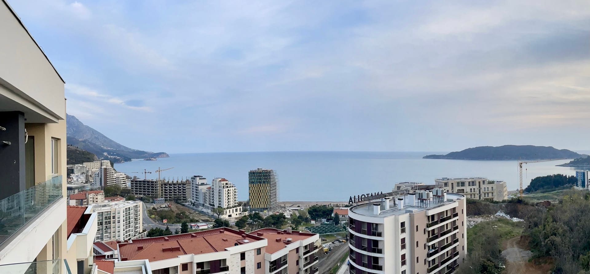 Panoramic view of the sea and the city of Bečići, Montenegro, from the balcony of a modern apartment in a residential complex.