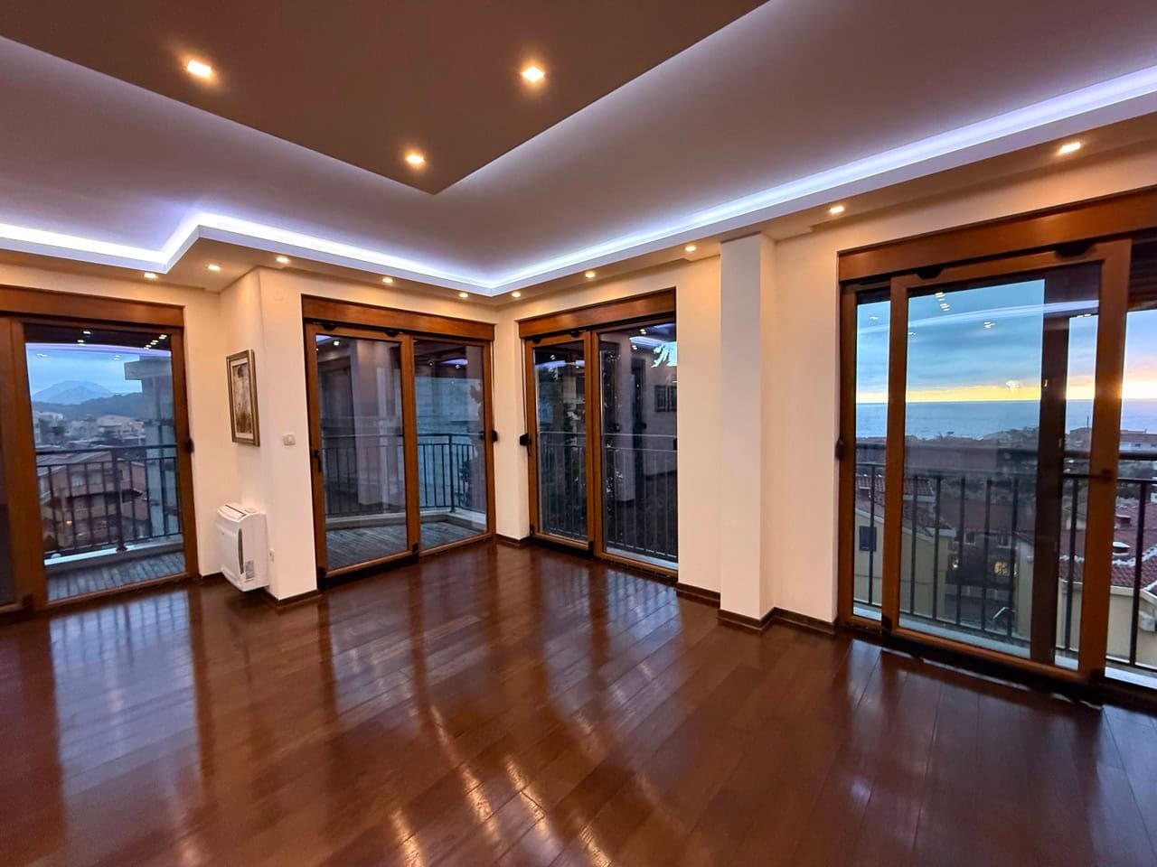 Living room with panoramic windows and sea view in an apartment, Petrovac, Montenegro: parquet flooring and a modern ceiling.