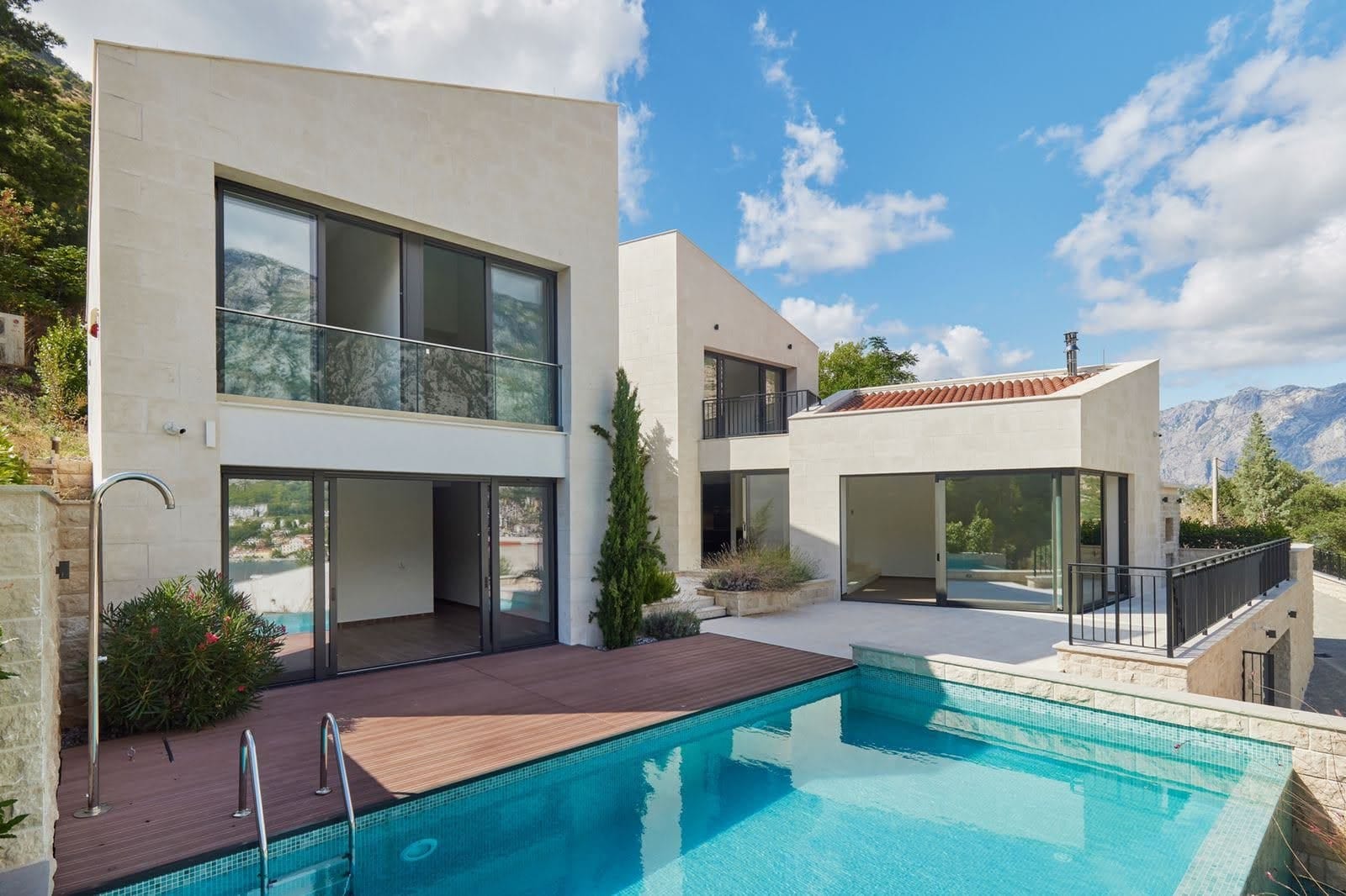 Modern villa with a pool and terrace in Prčanj, Montenegro: panoramic windows, stone finishes, and mountain views.