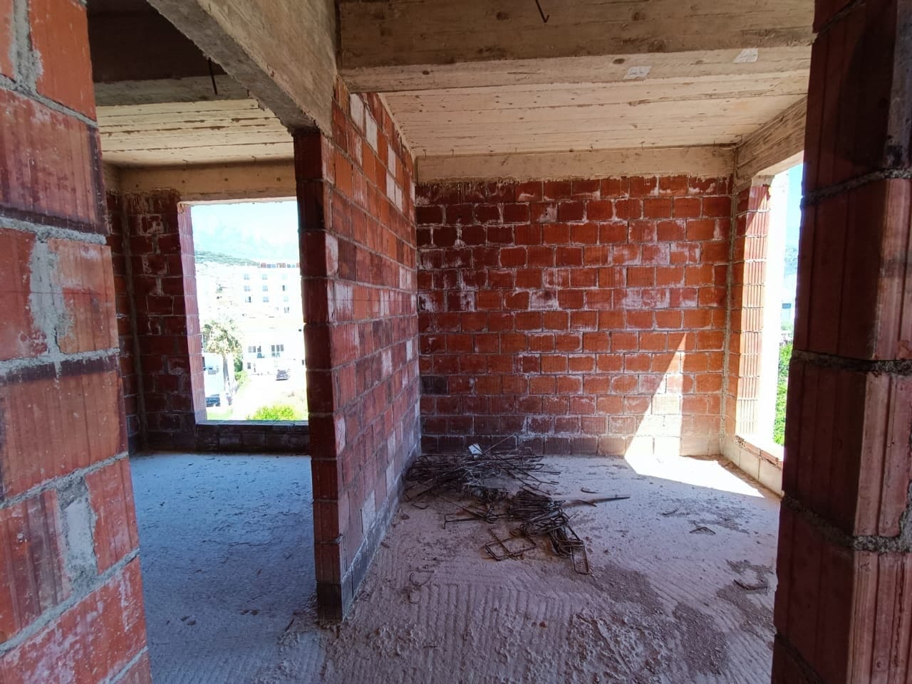 Apartment under construction in the Shushan residential complex, Montenegro: brick walls unfinished, concrete slabs, and a view from the windows.