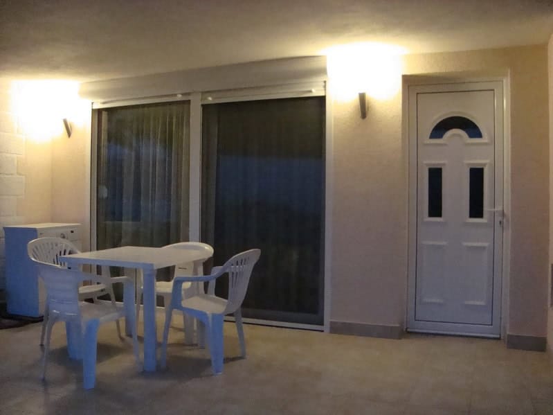 Covered terrace with plastic furniture and panoramic glazing in a house, Krašići, Montenegro.