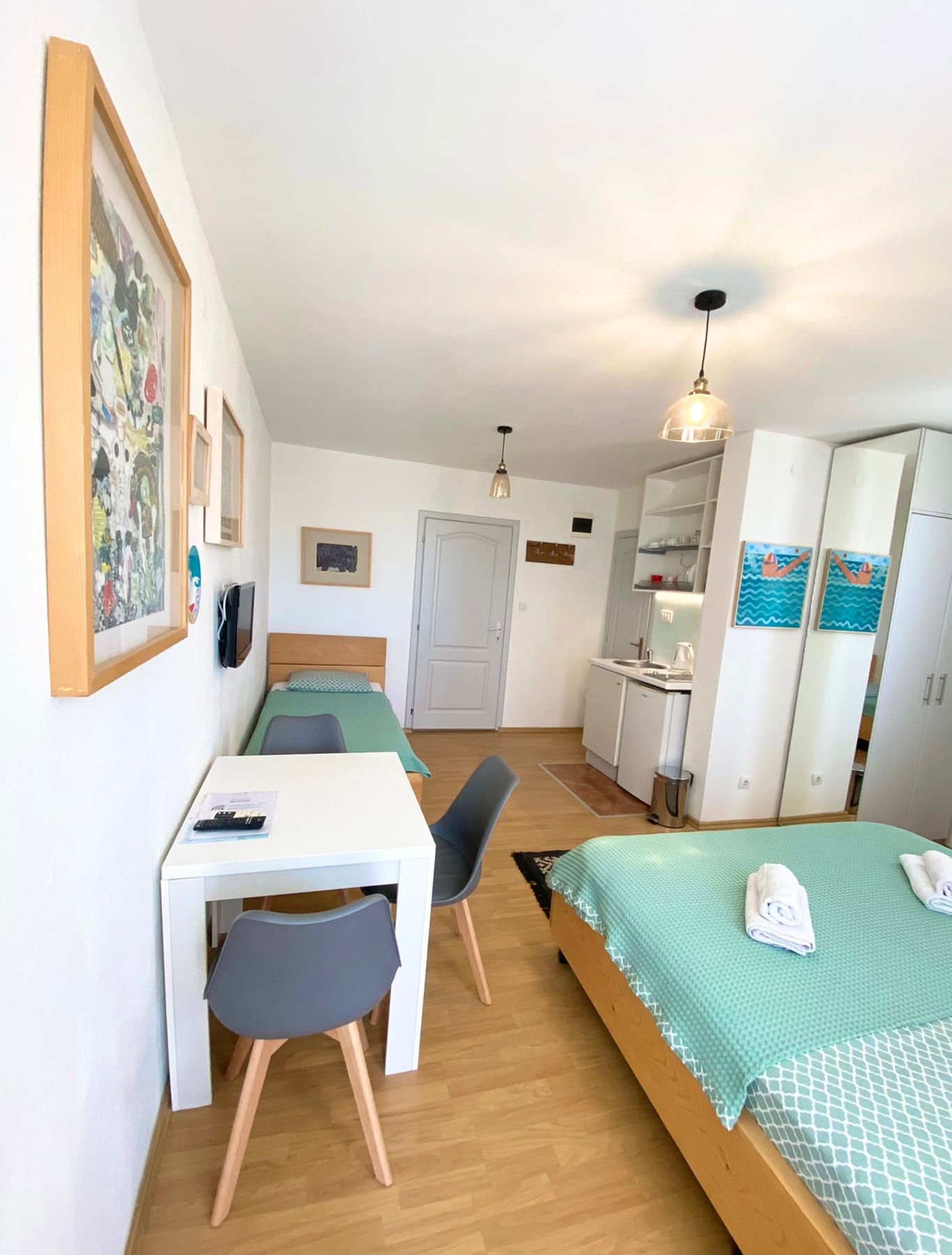 Bedroom interior in a house in Shushan, Montenegro: a double bed, dining area, and a kitchenette with modern furniture.