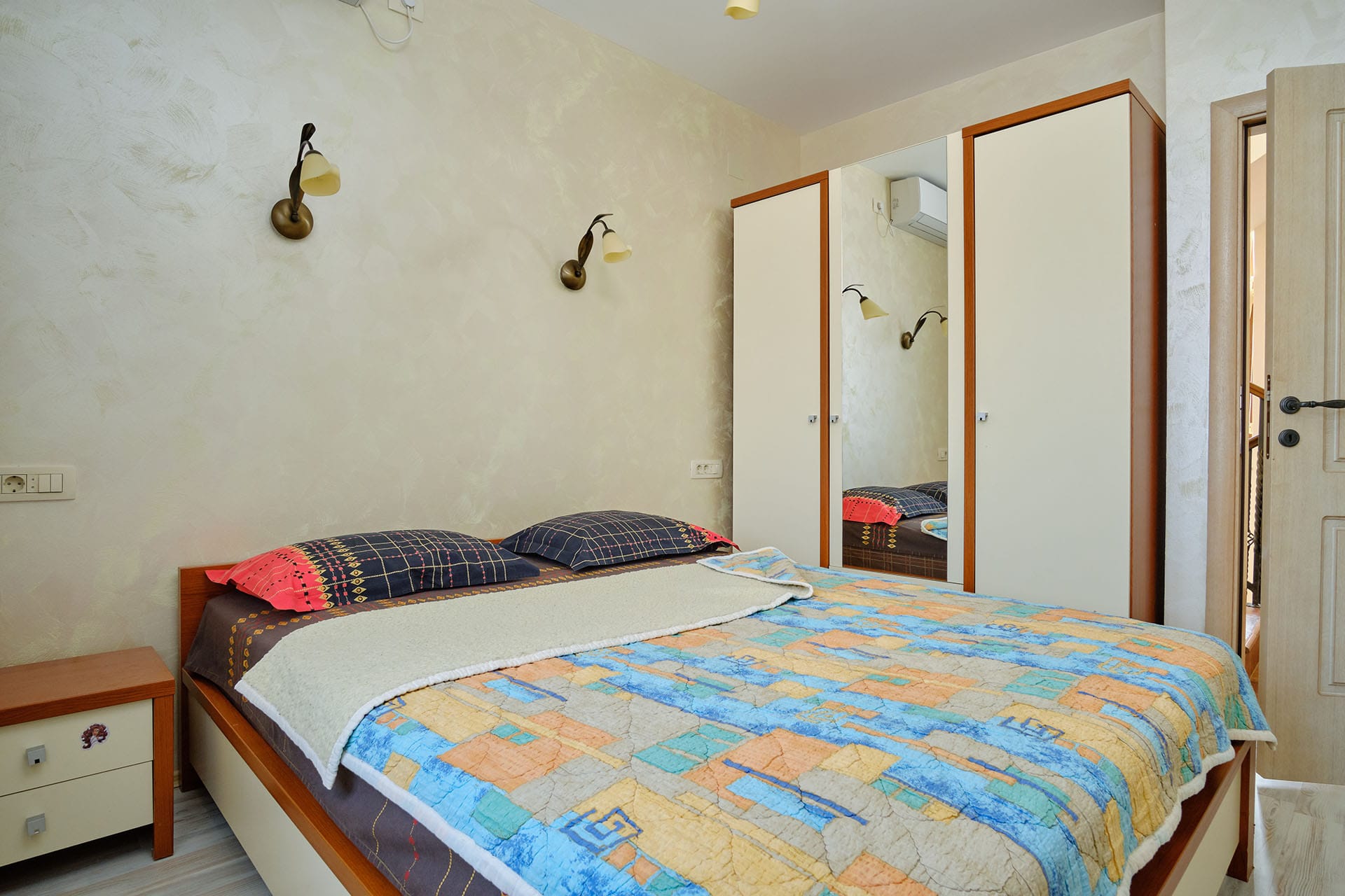 Cozy bedroom with a double bed and mirrored wardrobe in a townhouse, Bigovo, Montenegro.