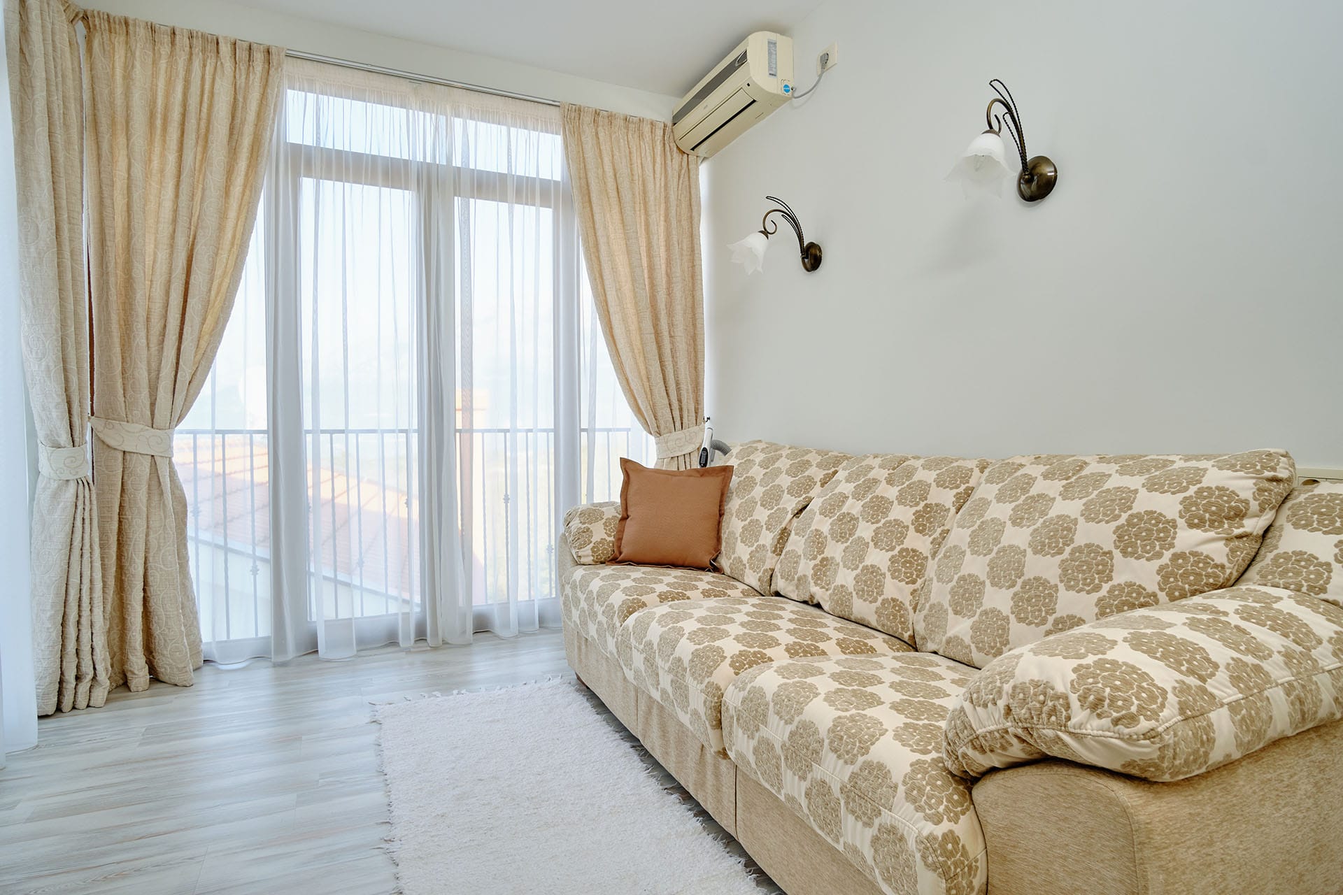 Living room in a townhouse in Bigovo, Montenegro: bright interior with a sofa, panoramic window, and access to the balcony.