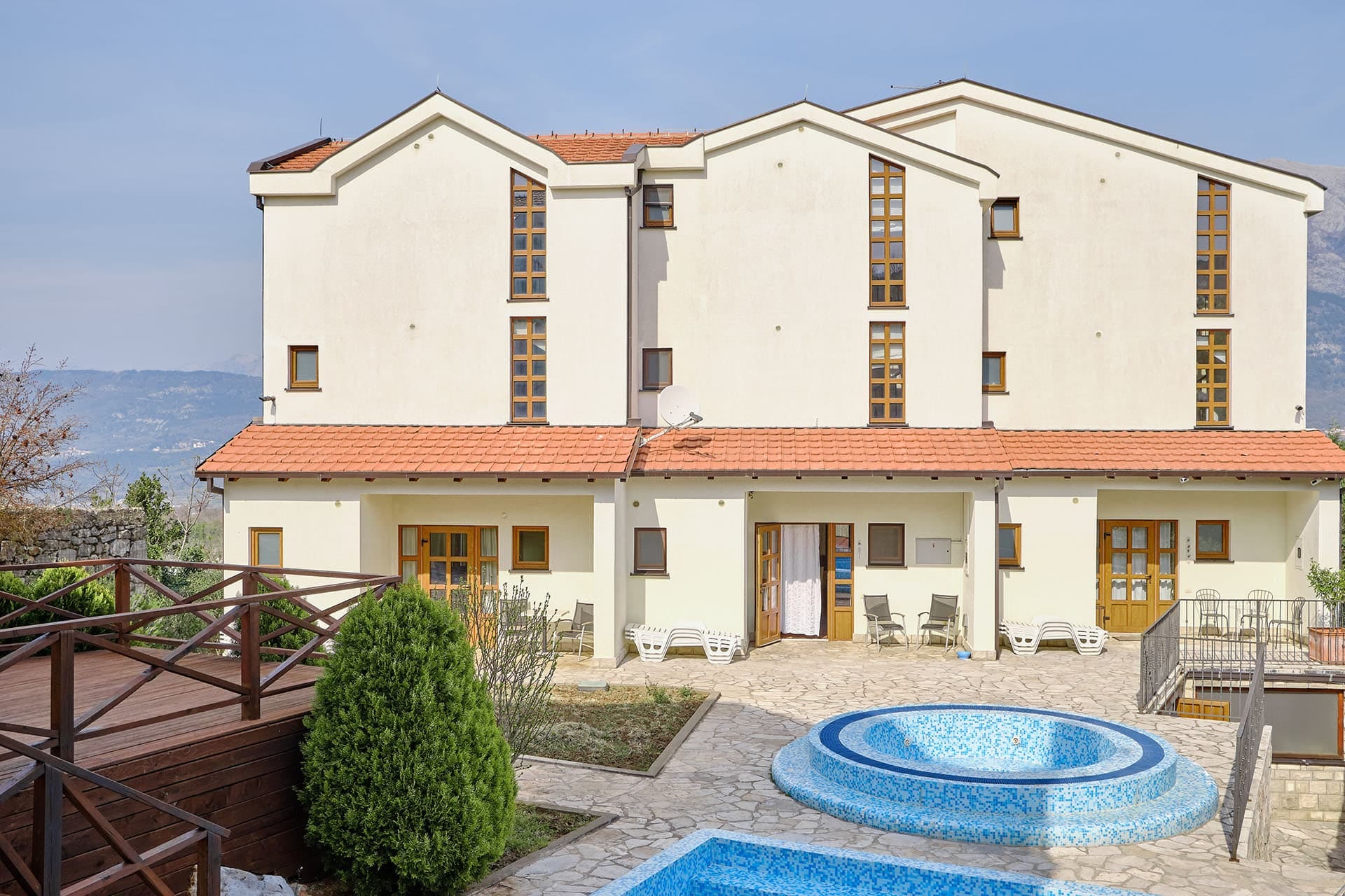Three-story townhouse with a pool and terrace in the village of Vranovici, Bigovo, Montenegro. Front view of the house with a jacuzzi.