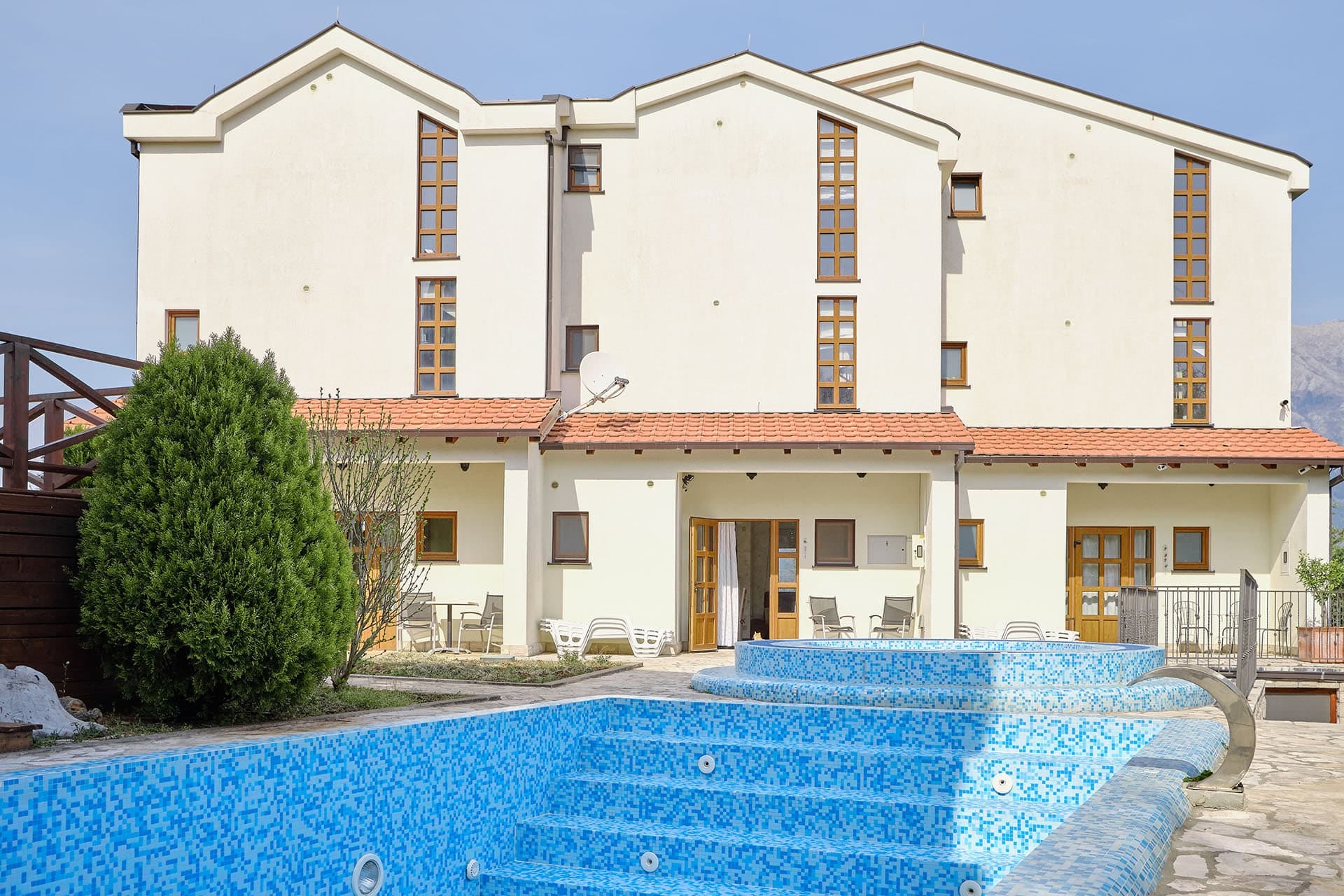 Three-story townhouse with a pool and terrace in Bigovo, Montenegro. Front view of the house with a relaxation area.