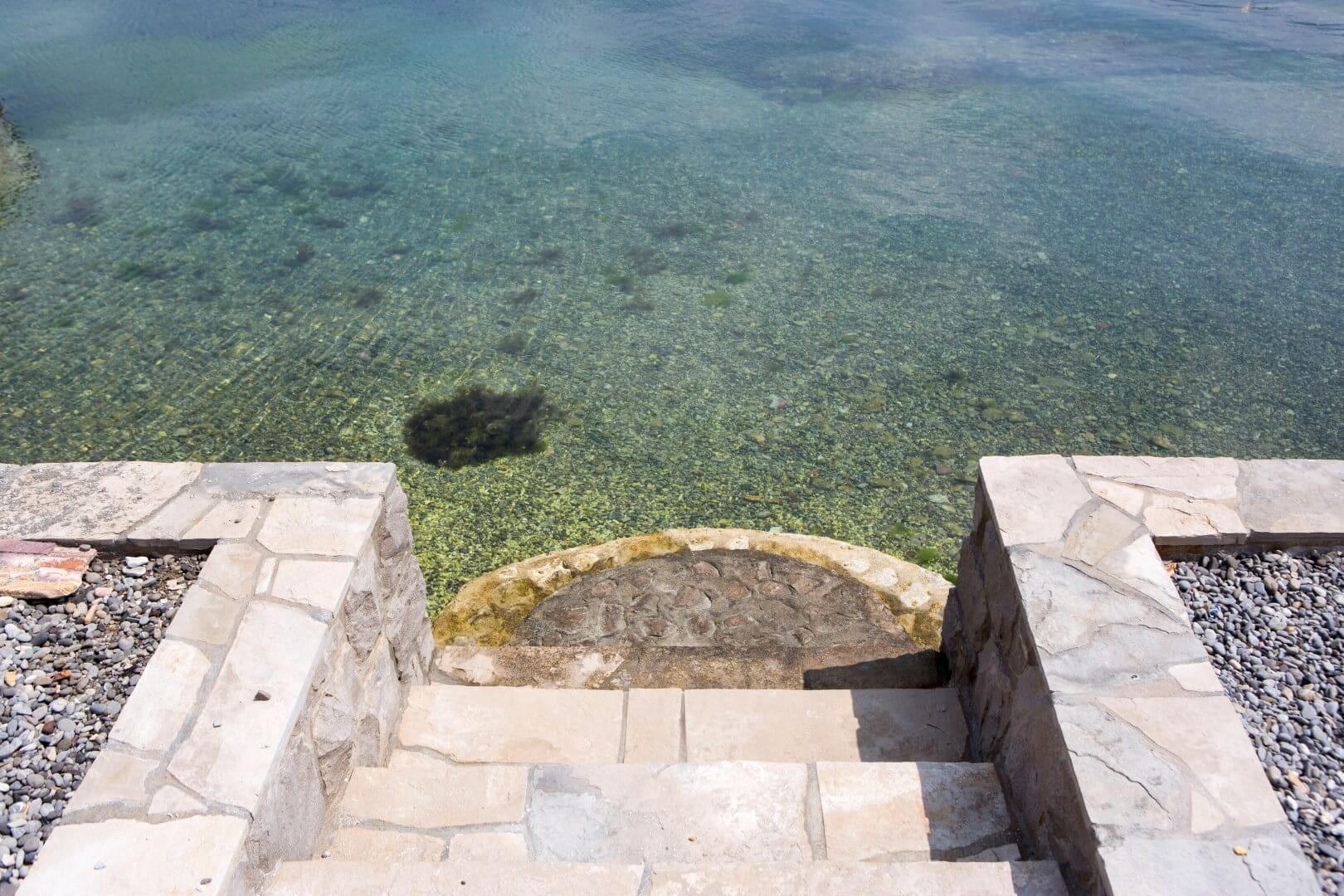 Stone staircase to the clear sea at a villa in Krašići, Montenegro: direct access to the water from a private beach.