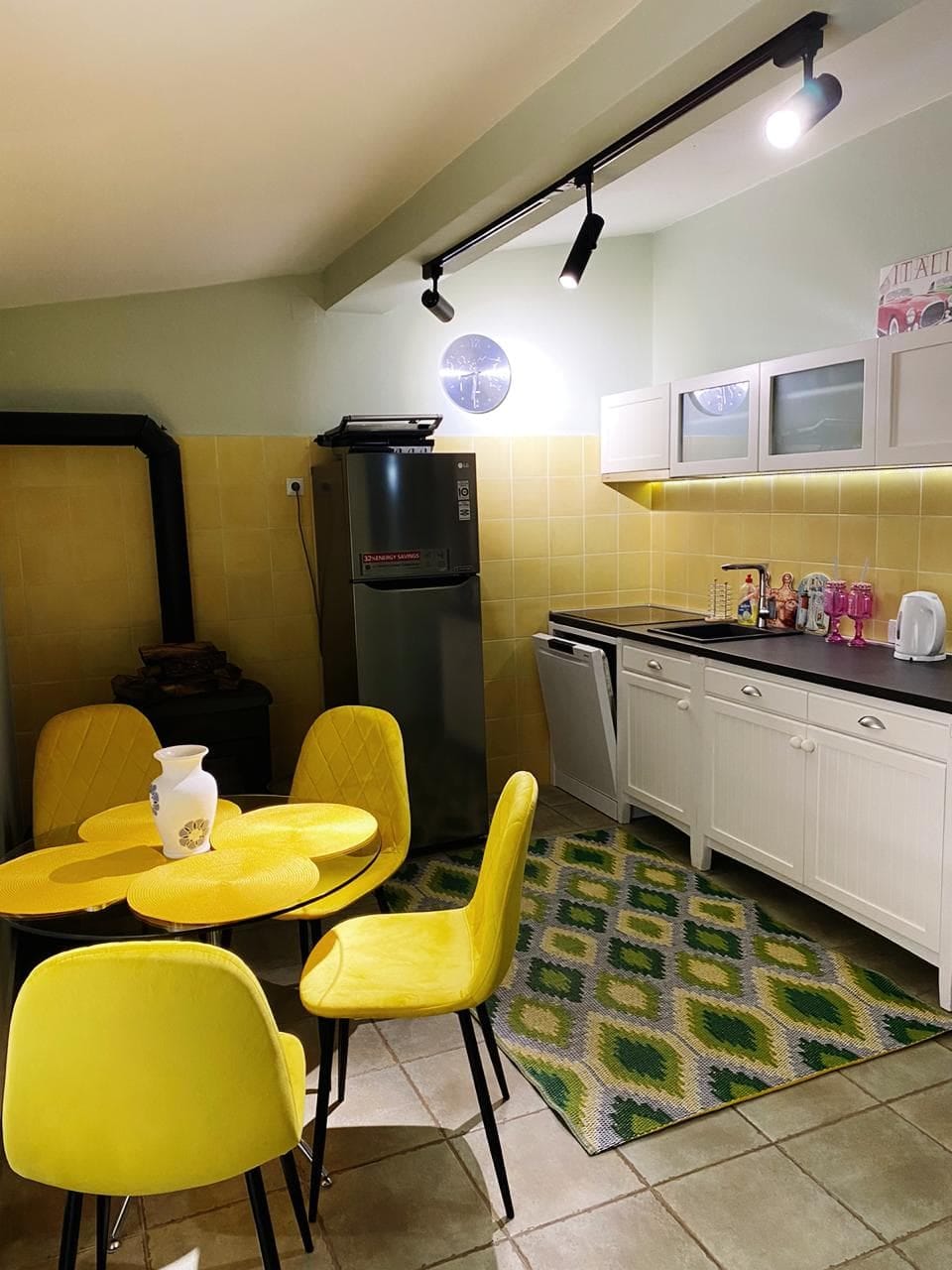 Kitchen with yellow chairs and dining area in a villa in Shushan, Montenegro: modern furniture and appliances.