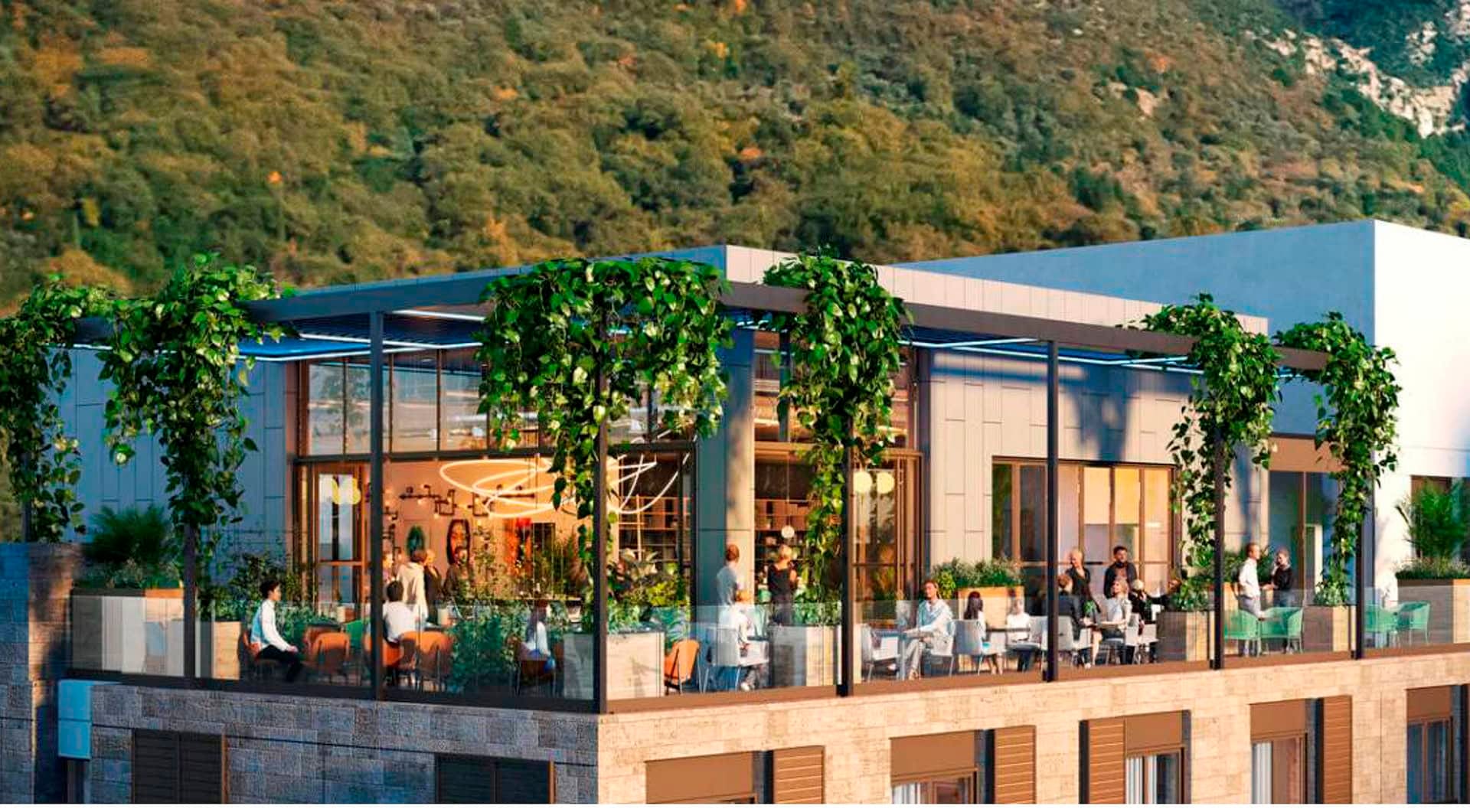 Open terrace of the Boka Place hotel in Tivat, Montenegro: modern architecture, landscaping, and panoramic mountain views.