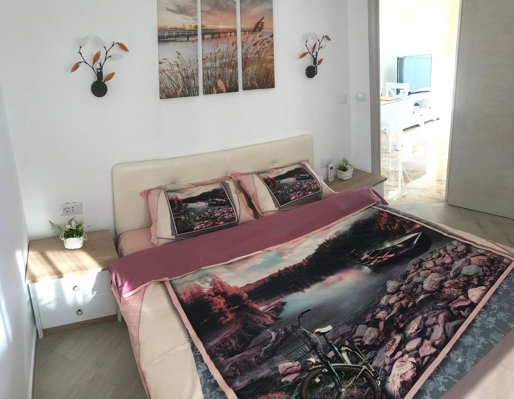 Cozy bedroom with a double bed in an apartment, Dobri Vody, Montenegro: bright interior and modern furniture.