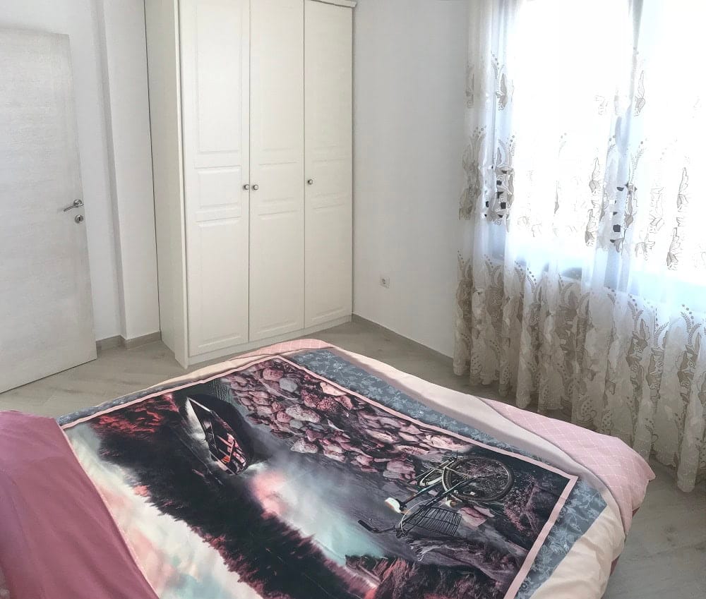 Bright bedroom with a white wardrobe and a double bed in an apartment, Dobri Vody, Montenegro.
