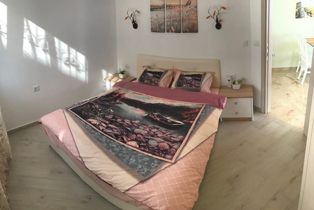 Cozy bedroom with a double bed in an apartment in Dobri Vody, Montenegro: bright interior and modern furniture.