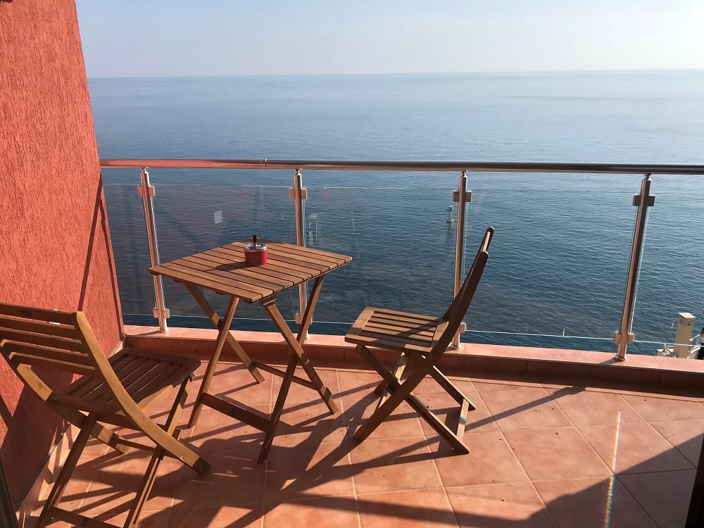 Balcony with wooden furniture and panoramic sea view in an apartment, Dobrota, Montenegro