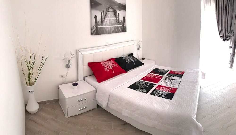 Modern bedroom with white furniture in an apartment, Dobri Vody, Montenegro: double bed and stylish decor.