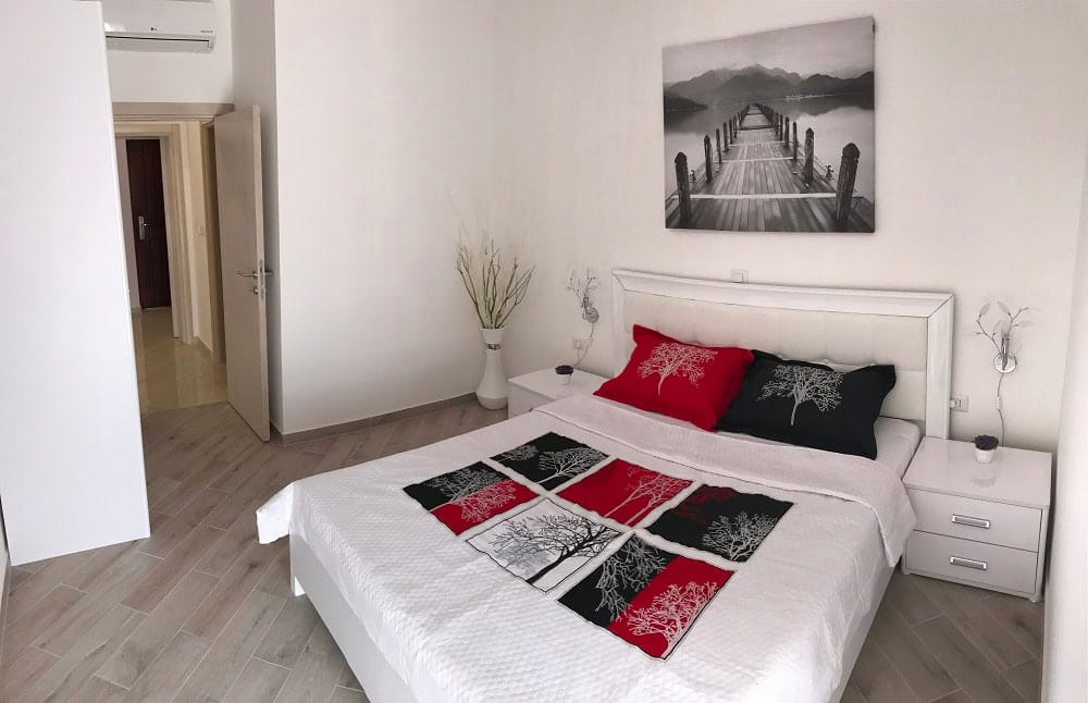 Bright bedroom in an apartment, Dobri Vody, Montenegro: double bed, modern furniture and decor in the interior.