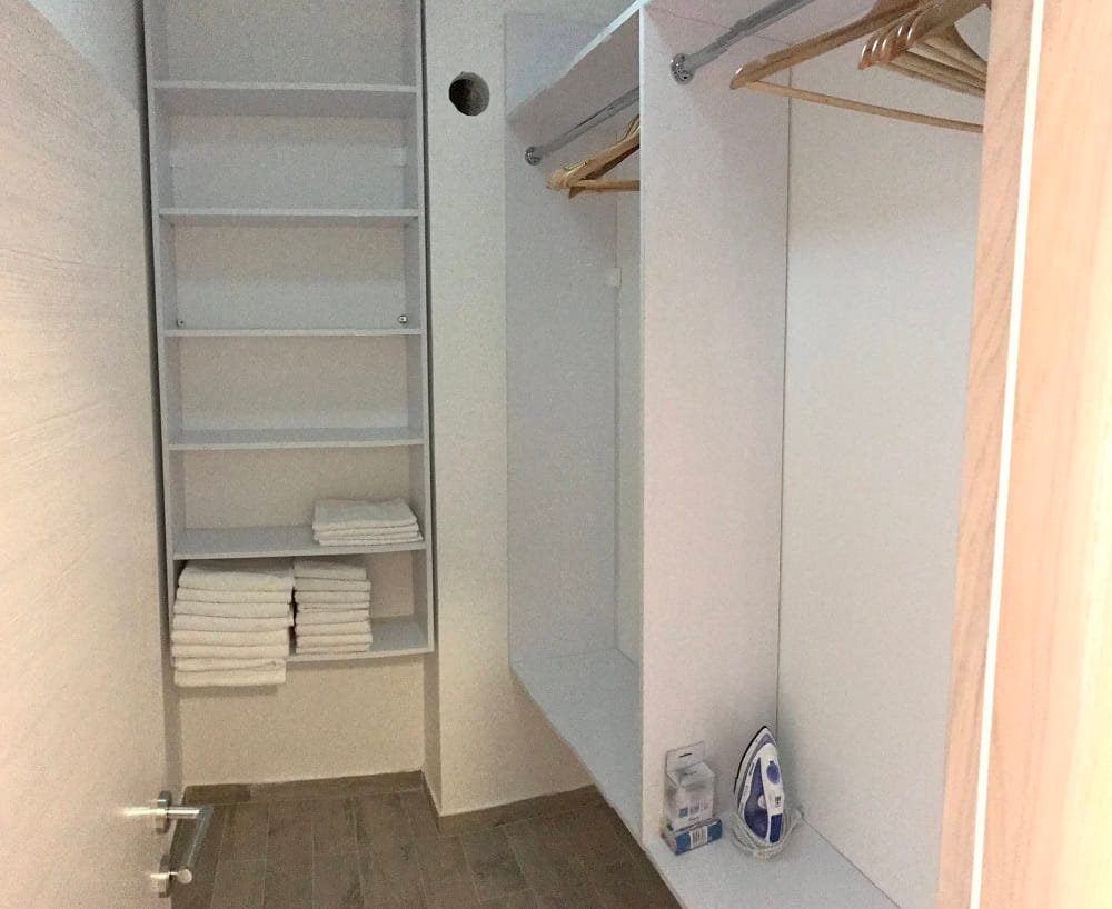 Built-in walk-in closet with shelves and hangers in the apartment, Dobri Vody, Montenegro. Convenient clothing storage system.