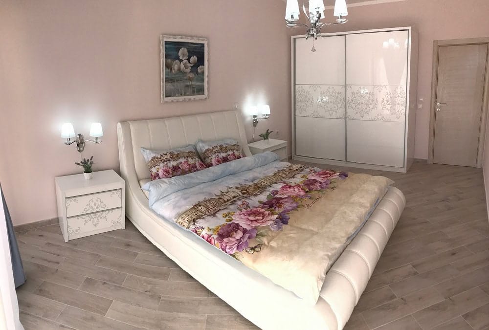 Bright bedroom with a white bed and sliding wardrobe in an apartment in Dobri Vody, Montenegro. Modern interior.