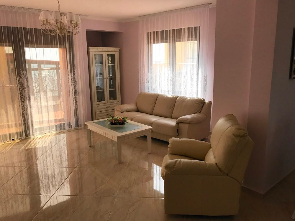 Bright living room with leather furniture and panoramic windows in an apartment, Dobri Vody, Montenegro.