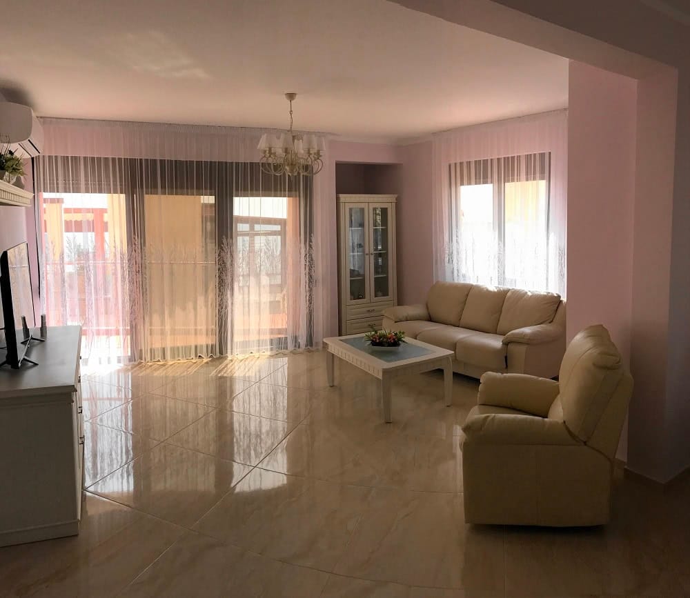 Bright living room with beige furniture and panoramic windows in an apartment, Dobrye Vody, Montenegro.
