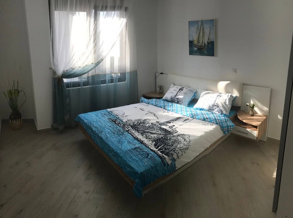 Bright bedroom with a double bed in an apartment, Dobrota, Montenegro: modern furniture and nautical decor.