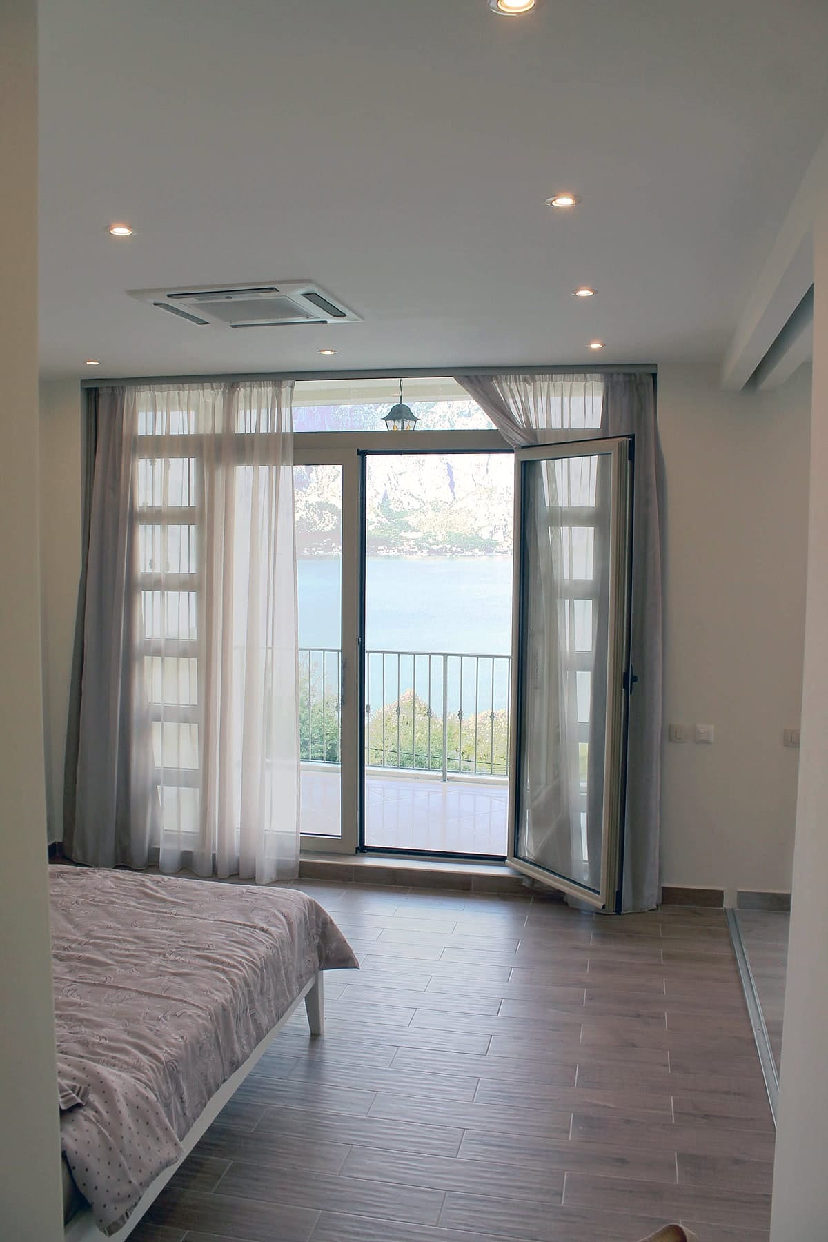Bedroom in an apartment in Prčanj, Montenegro: panoramic sea and mountain views, bright interior, access to the terrace.