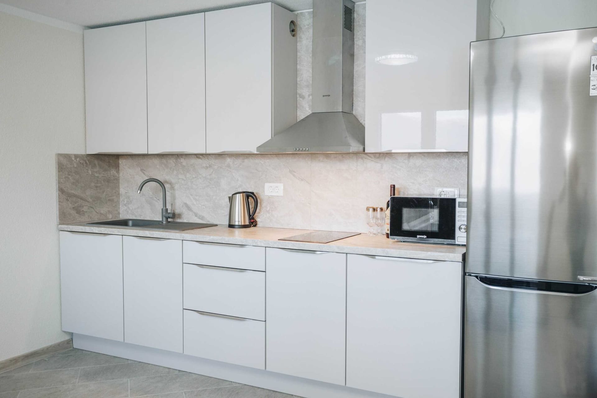 Modern white kitchen with Gorenje appliances in an apartment in a villa in Krašići, Montenegro.