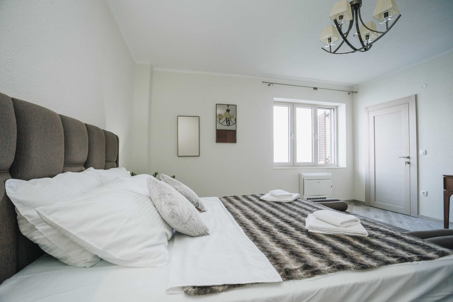 Bright bedroom with a double bed in a villa in Krašići, Montenegro: modern interior, upholstered headboard.