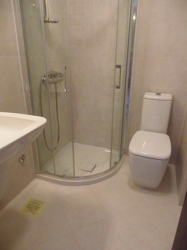 Modern bathroom with shower cabin in an apartment, Petrovac, Montenegro: light tiles and sanitary ware.