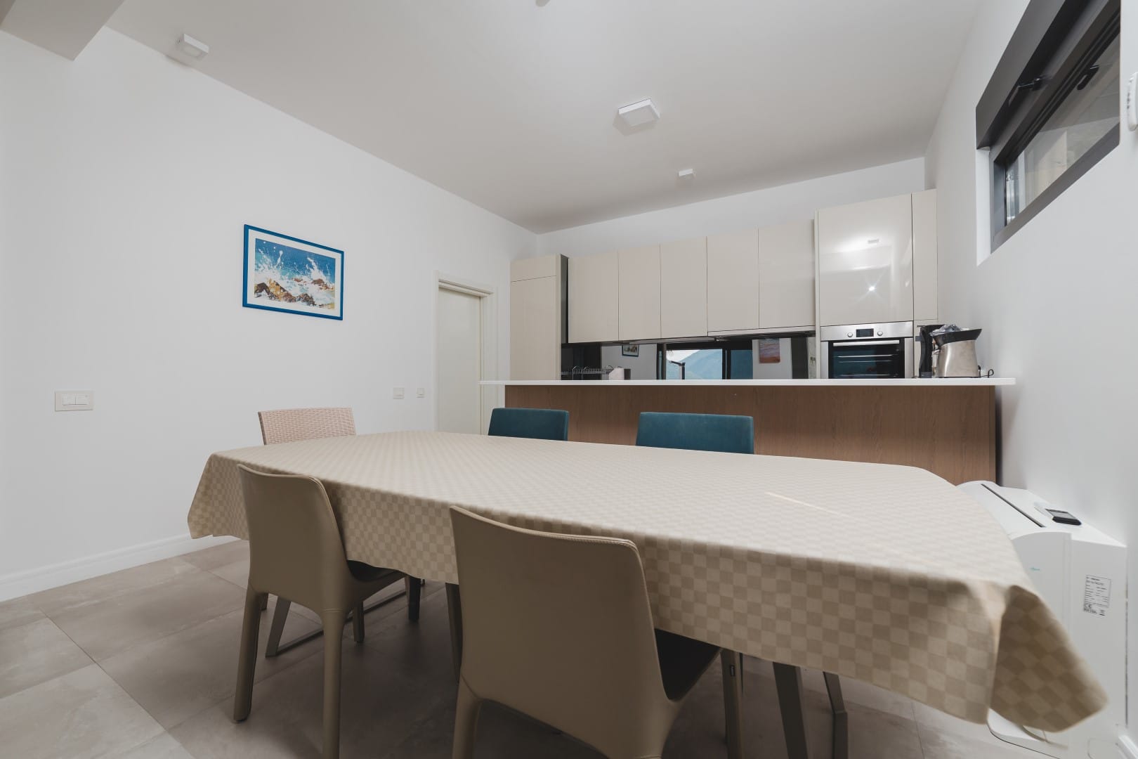 Modern kitchen-dining room in a villa in Strp, Montenegro: dining table, built-in cabinetry, and a bright interior.