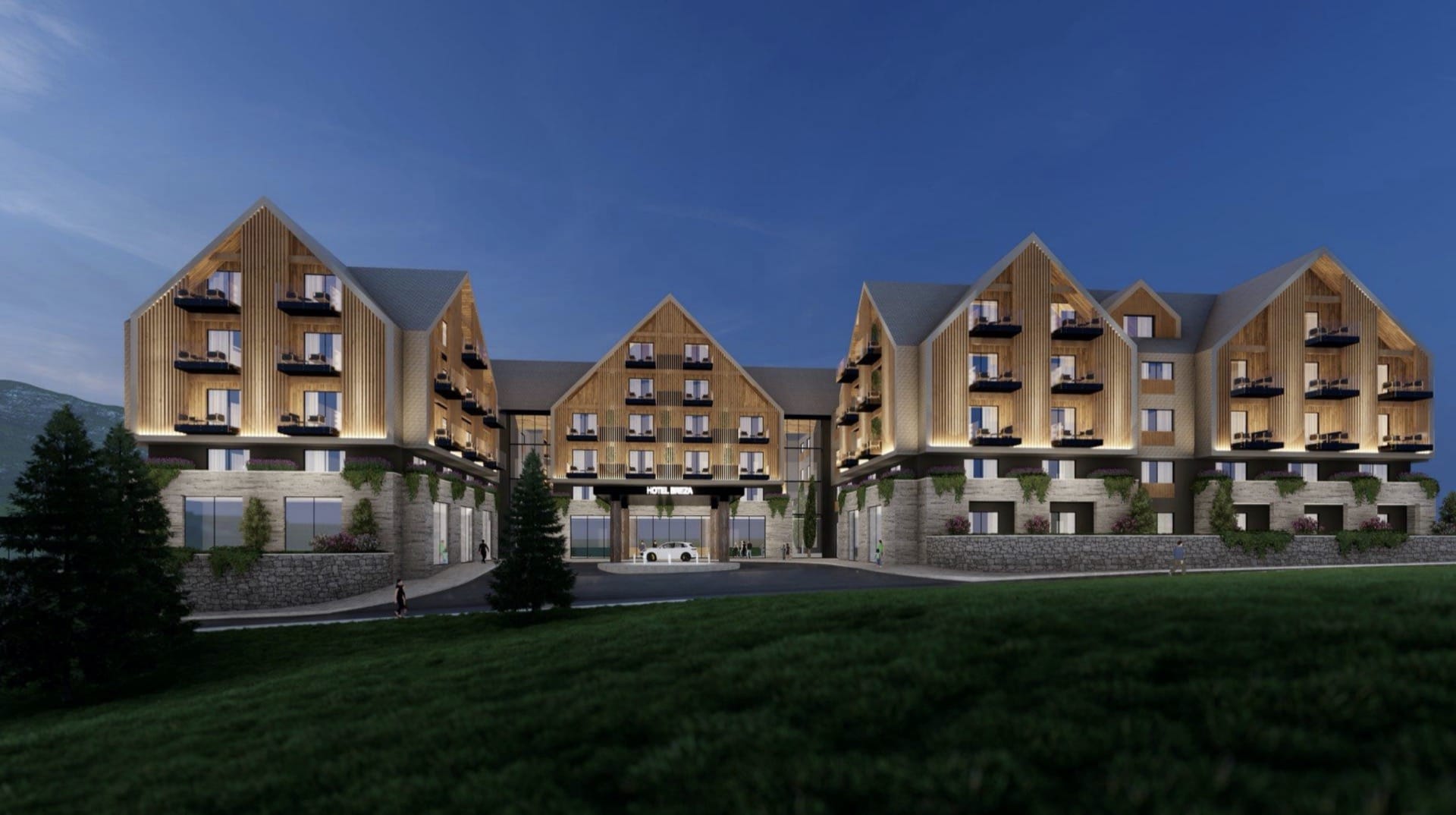 Facade of the Breza Hotel in Kolašin, Montenegro: modern architecture with wood cladding and a stone base at night.