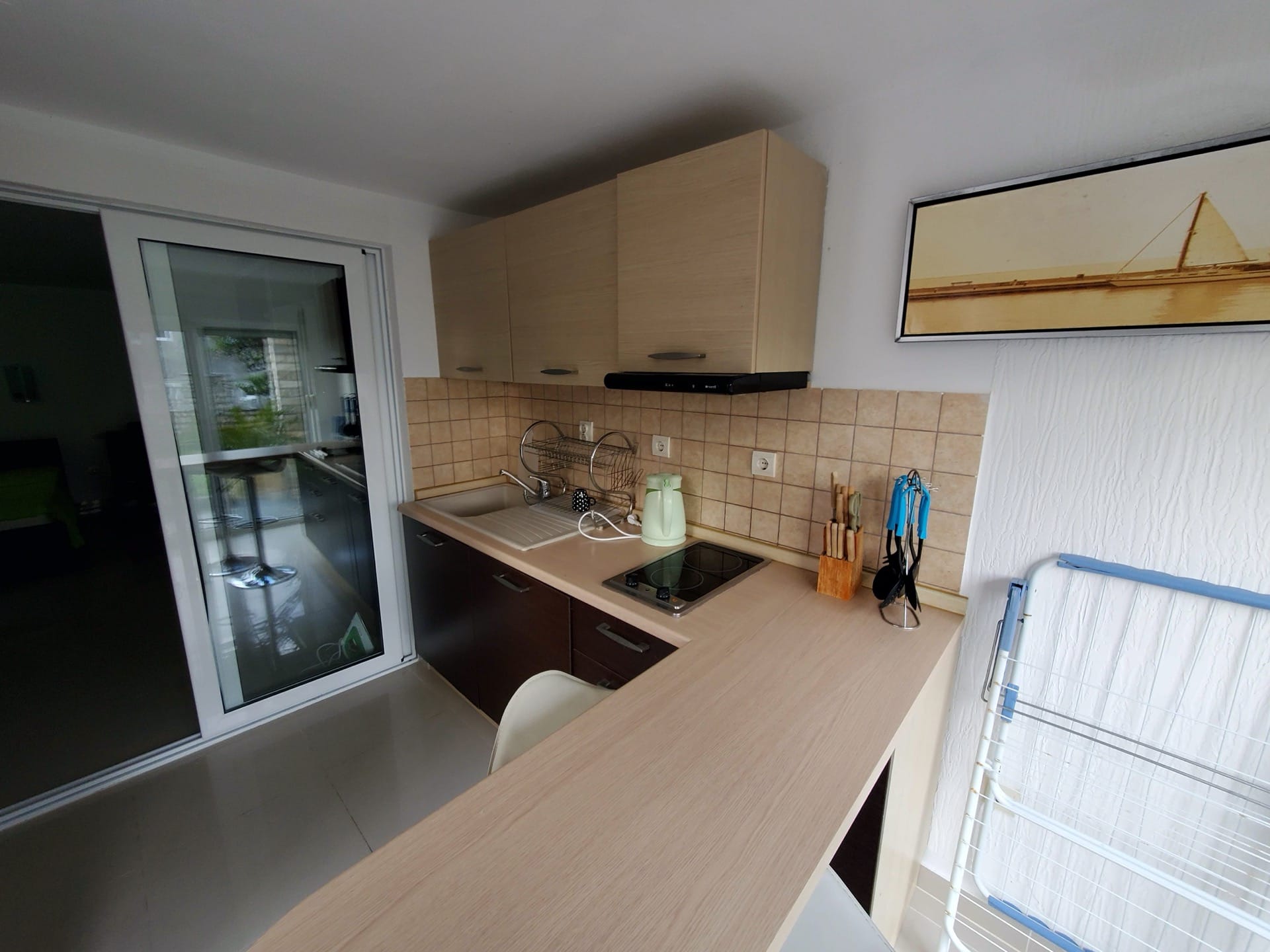 Kitchen in the Biela Hotel, Montenegro: light-colored cabinetry, built-in stove, breakfast bar, and access to the terrace.