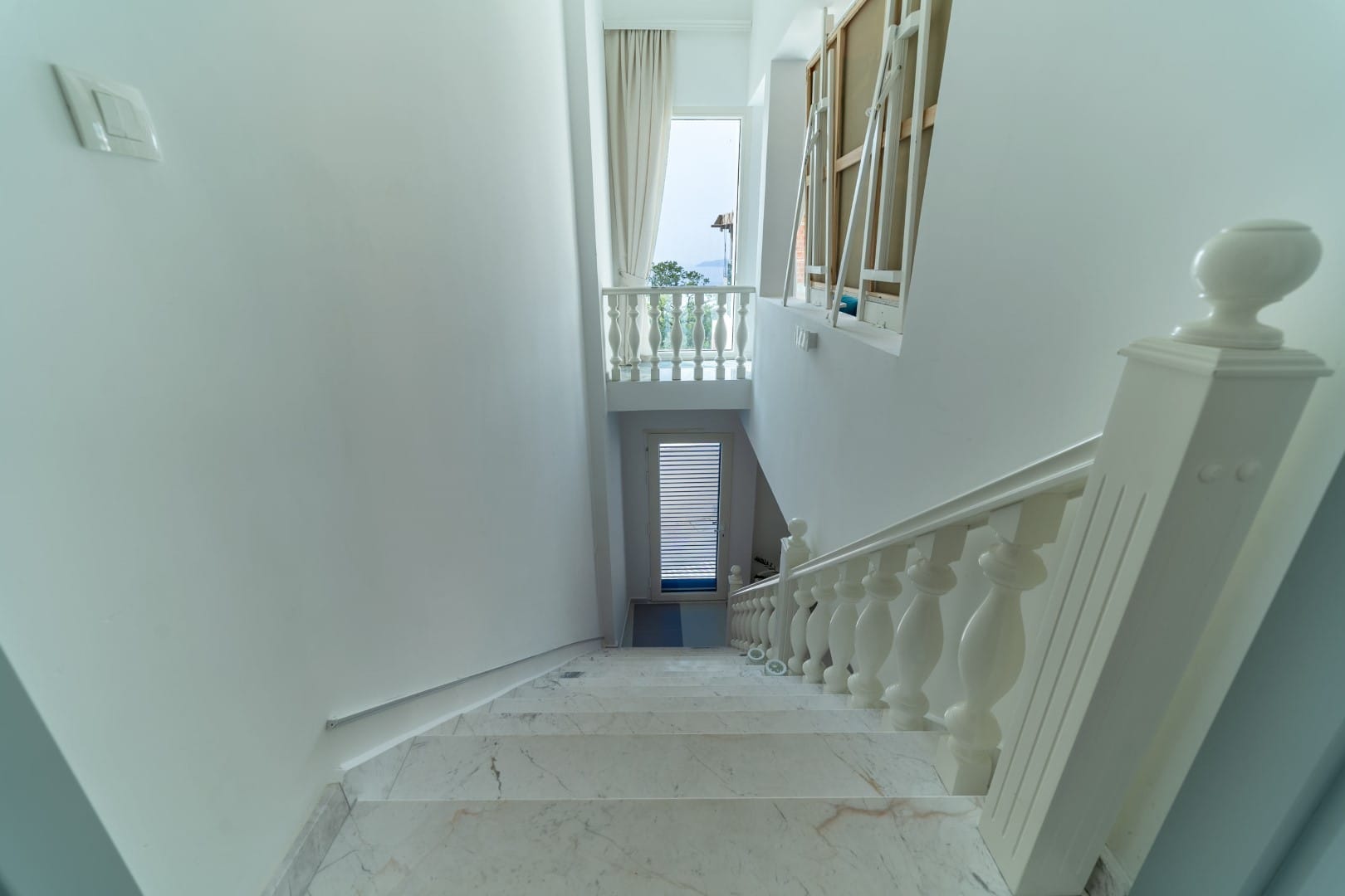 White marble staircase with classic balusters in a house, Blizikuće, Montenegro, view of the terrace and the sea.