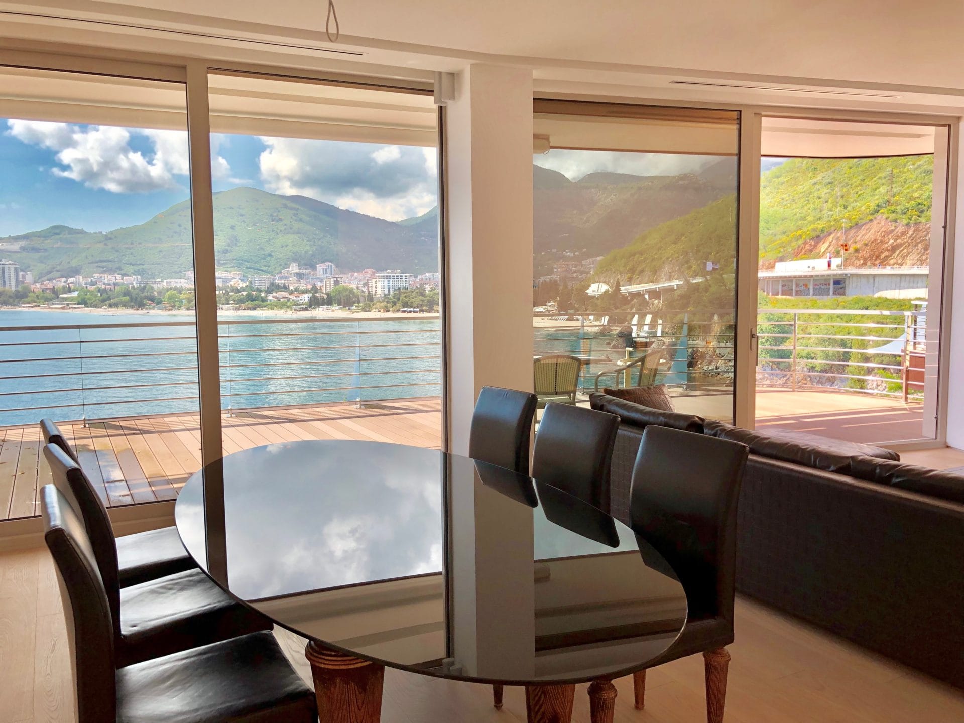 Living room with panoramic sea and mountain views in an apartment in Budva, Montenegro: dining table and terrace.