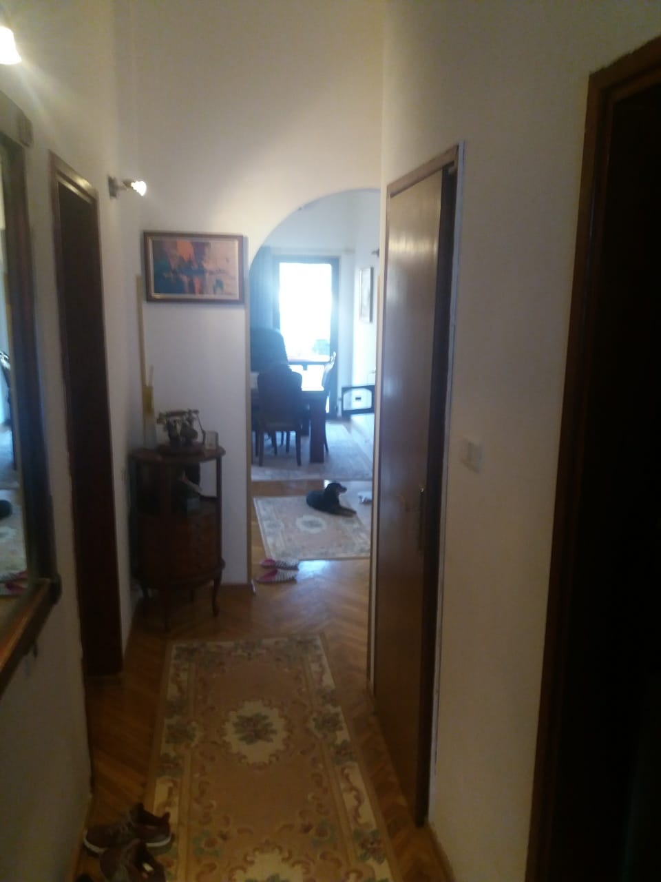 Hallway with parquet flooring and an arched passage to the living room in a house, Muo, Montenegro.