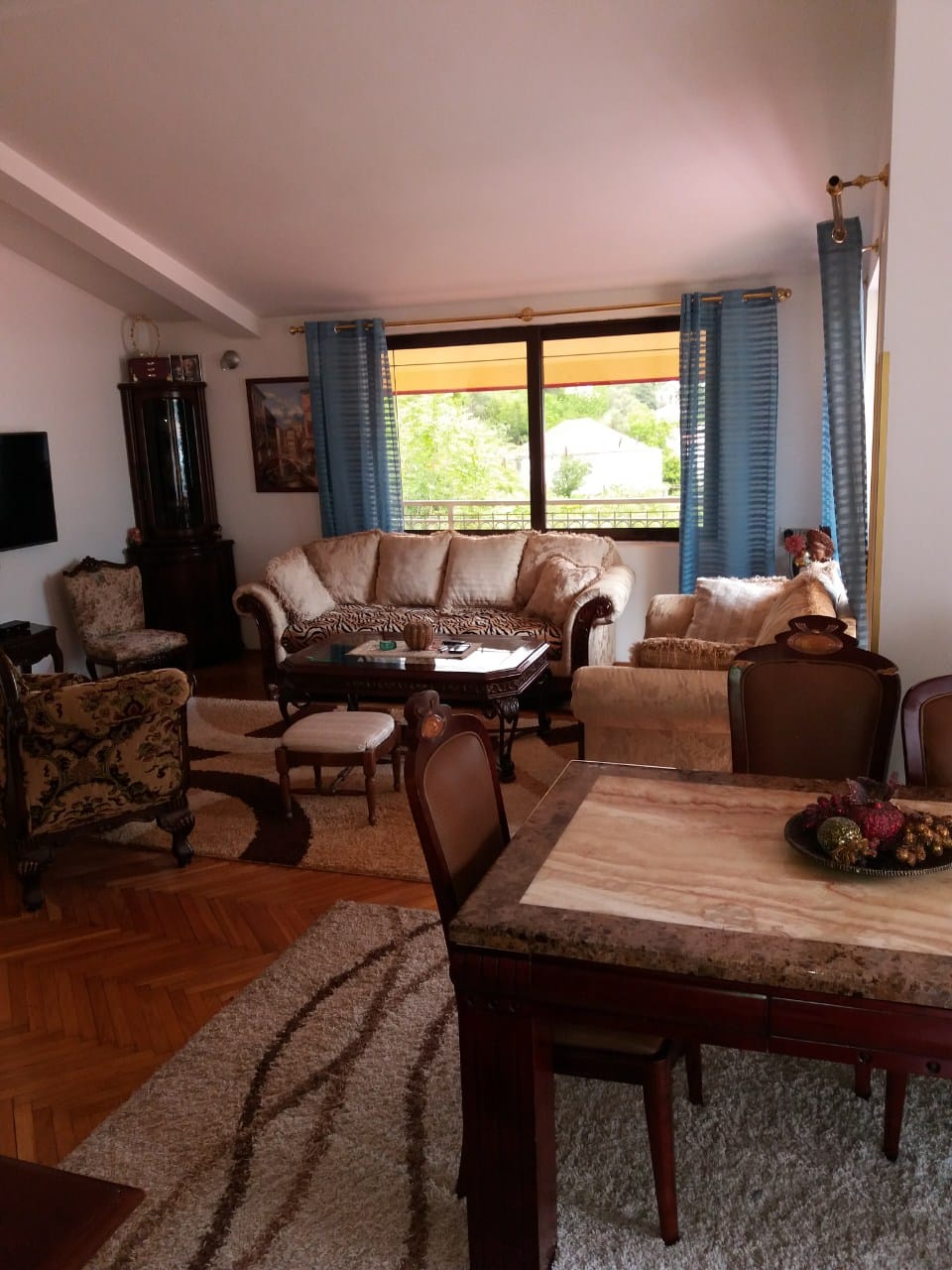 Spacious living room with classic furniture, parquet flooring, and a view of greenery in a house, Muo, Montenegro.