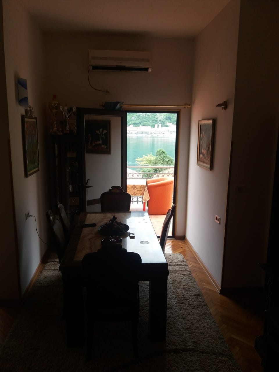 Living room with a dining table and access to a terrace with sea views in a house in Muo, Montenegro.