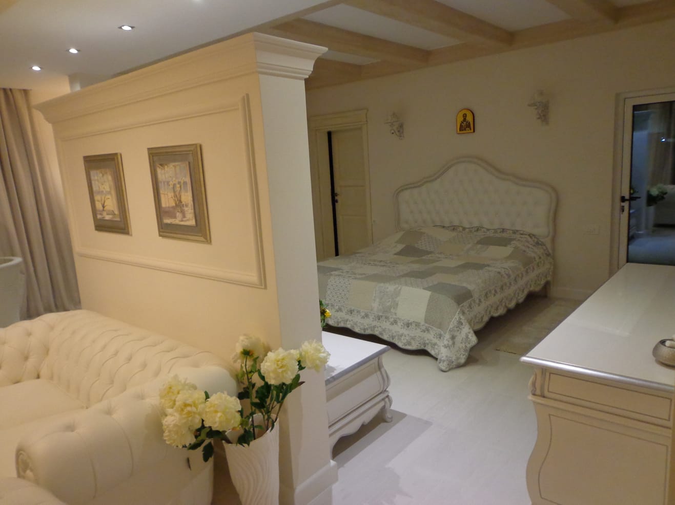 Bright classic-style bedroom in a villa in Dobri Vody, Montenegro: a double bed and a Chesterfield sofa.