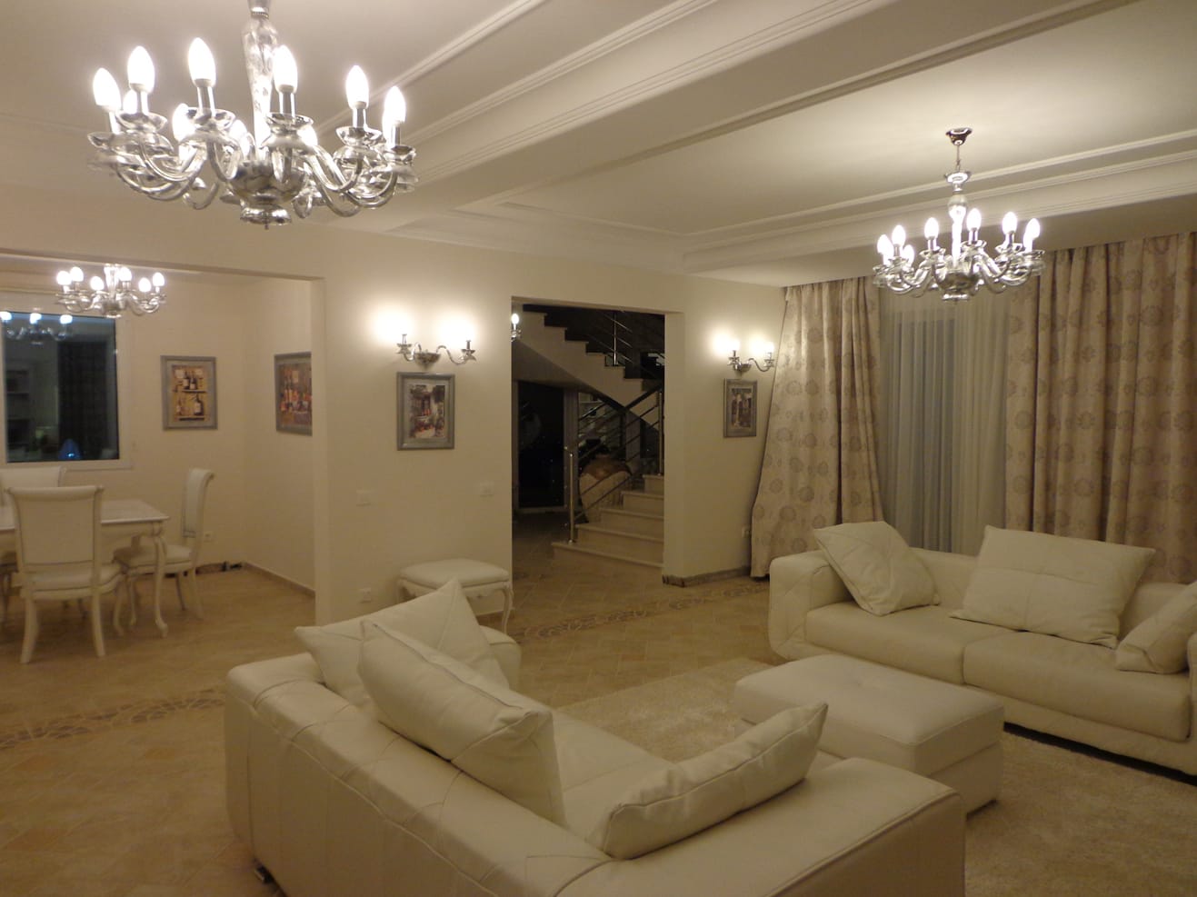 Spacious living room with white leather furniture and crystal chandeliers in a villa in Dobra Voda, Montenegro.
