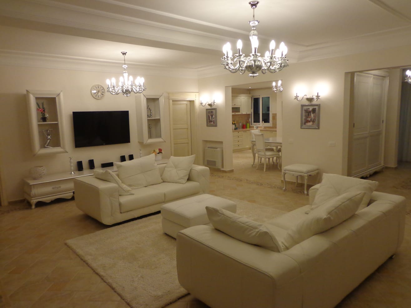 Spacious living room with white leather furniture in a villa in Dobra Voda, Montenegro: classic interior and kitchen.